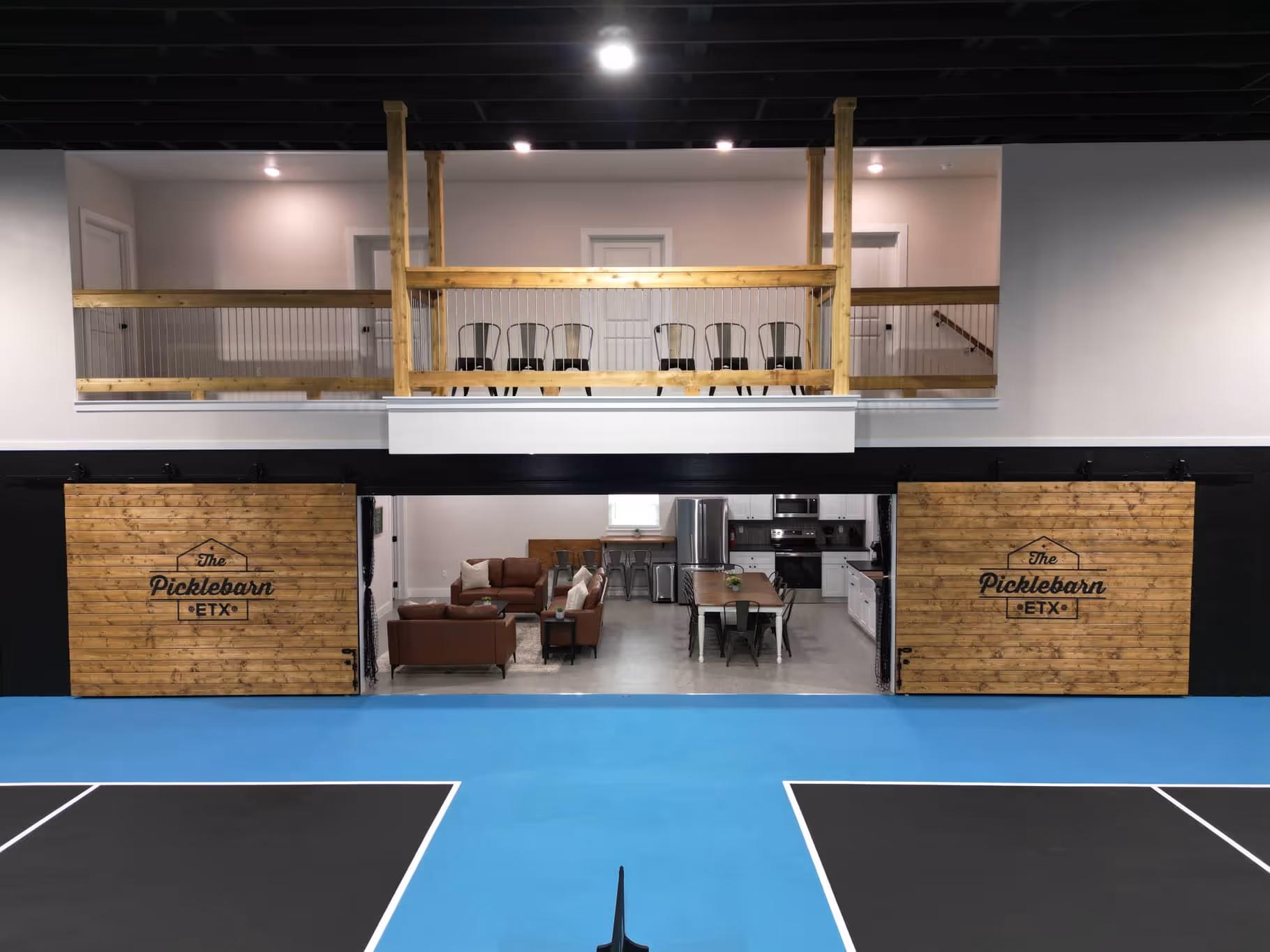 The Picklebarn ETX Airbnb living room and balcony looking out on pickleball courts